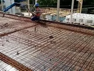 trabalhadores montando a armação com vergalhões.